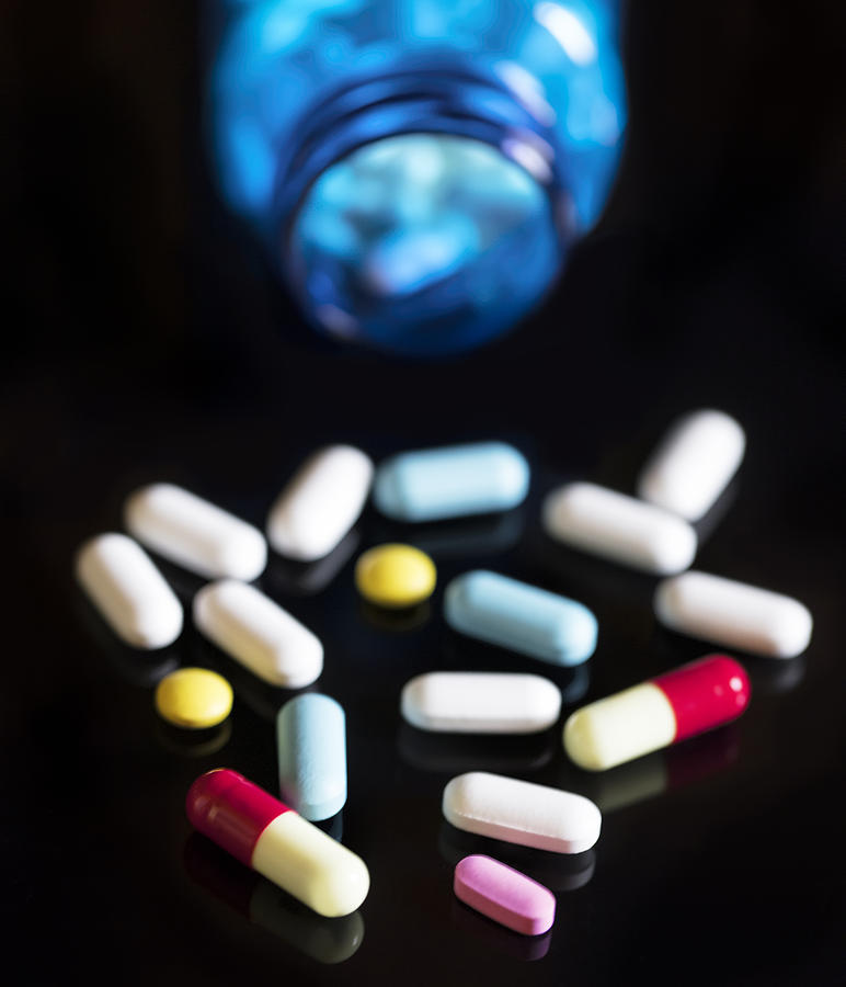 Spilled capsules and pills On black background. Medical concept Photograph by Mikroman6