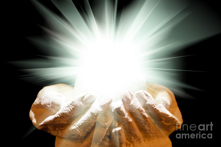 Spiritual light in cupped hands on a black background Photograph by Simon Bratt