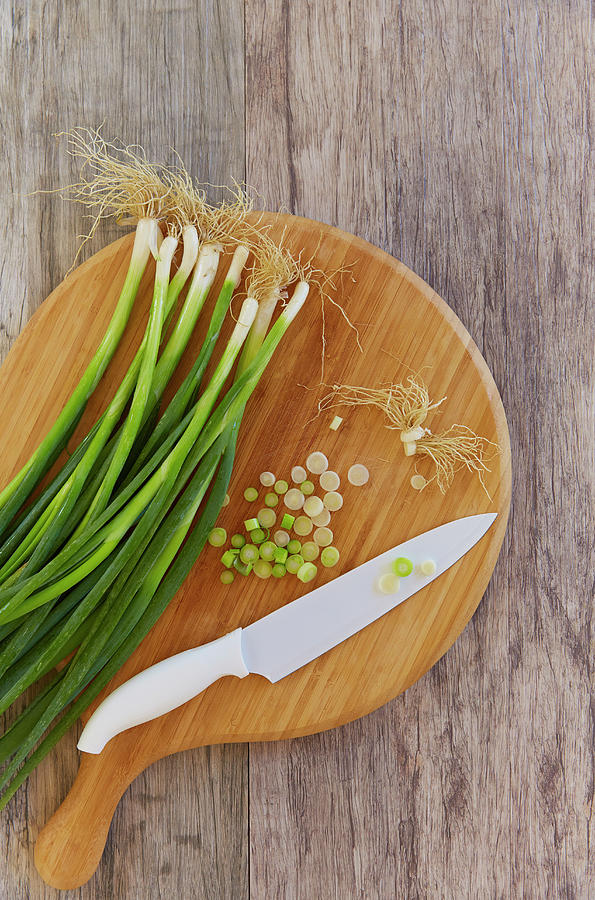 Spring Onions On Chopping Board Photograph by Colin Anderson Productions Pty Ltd