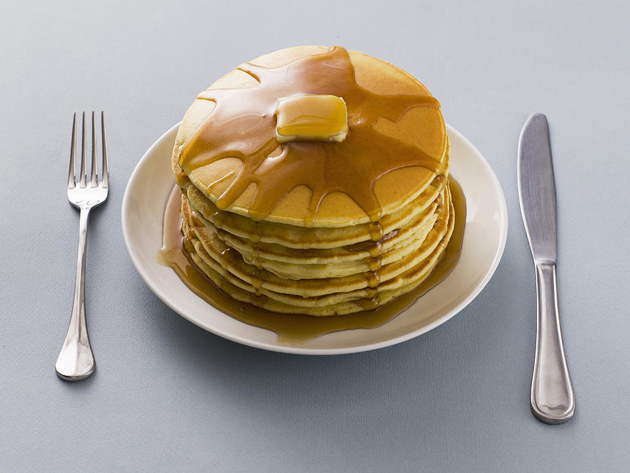 Stack of pancakes with butter and syrup on a plate Photograph by Thinkstock Images