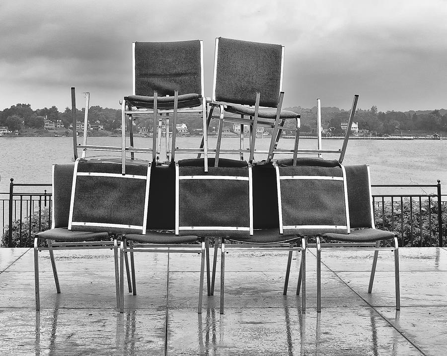 Stacked Chairs On Wet Plaza Photograph