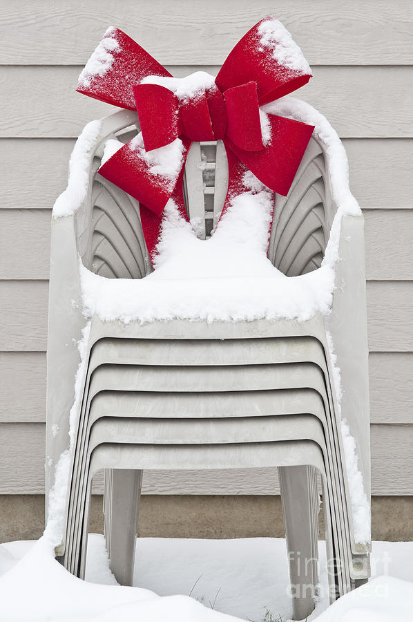 Stacked lawn chairs with red Christmas bow Photograph by Jim Corwin