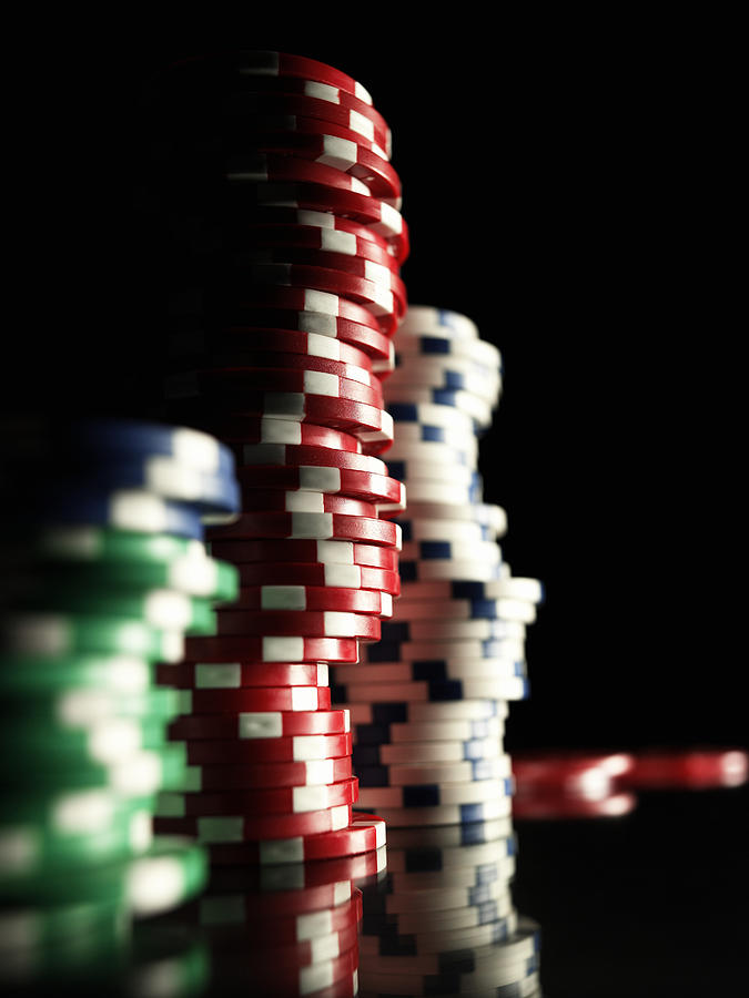 Stacks of gambling chips, close-up (focus on red chips) Photograph by Michael Blann