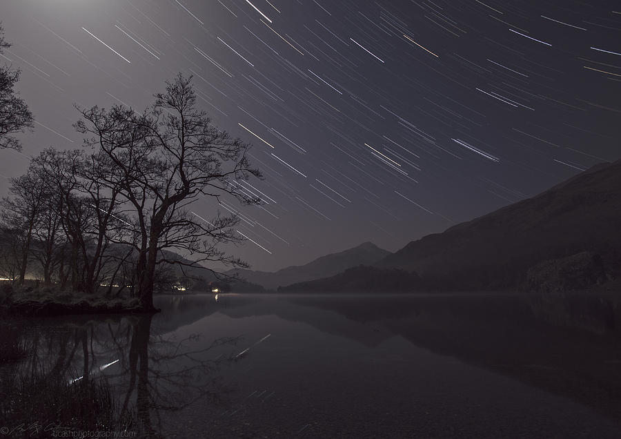 Star trails over lake Photograph by B Cash