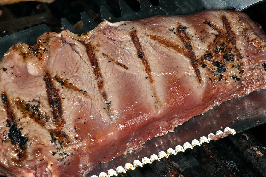 Steak in barbecue grill Photograph by Marek Poplawski