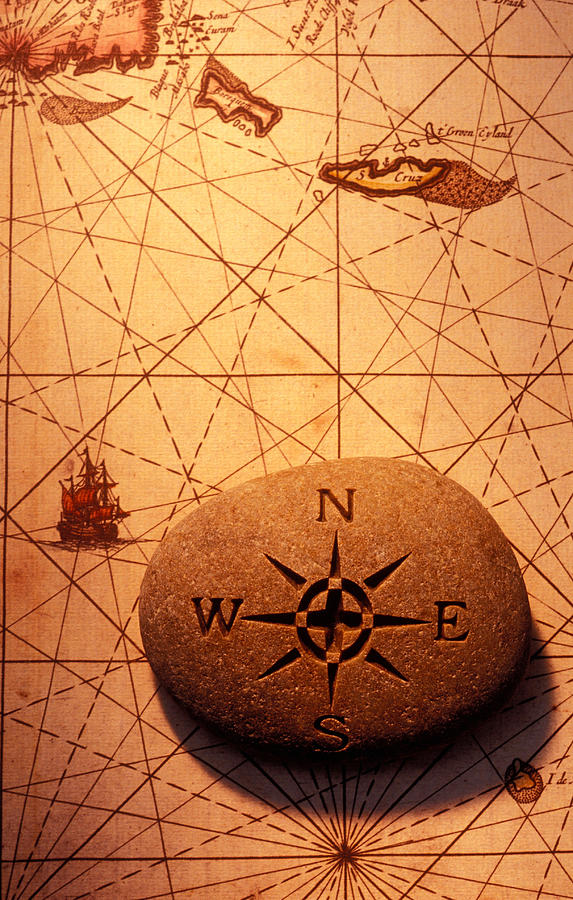 Stone compass on old map Photograph by Garry Gay