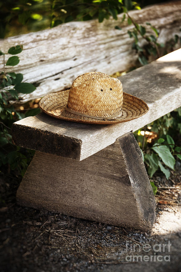 Straw hat on wooden bench Photograph by Sandra Cunningham