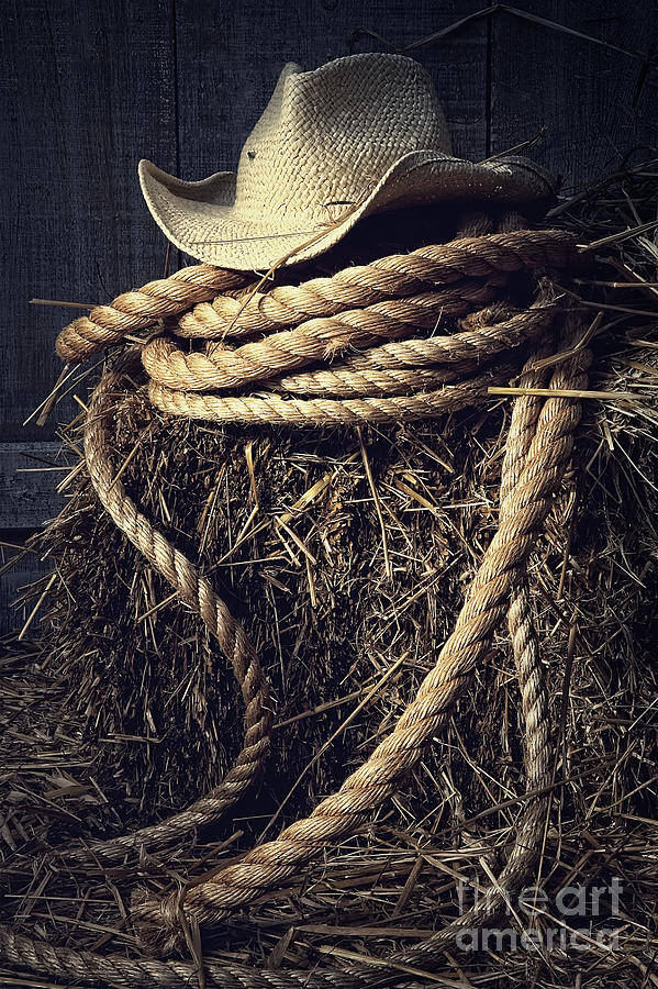 Straw hat with rope on a bale of hay in barn Photograph by Sandra Cunningham