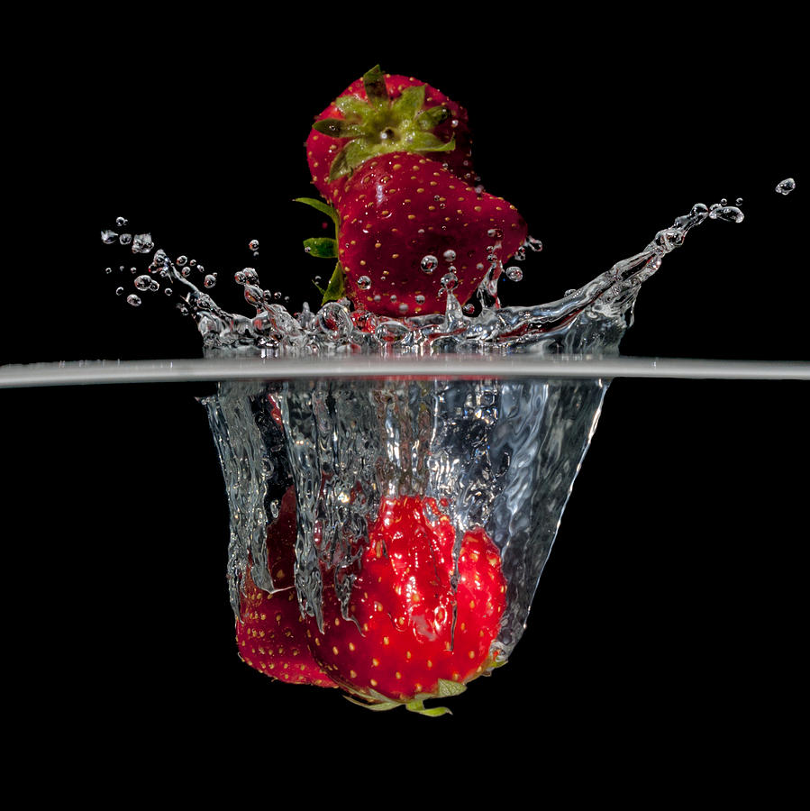 Strawberries splashing in water Photograph by Mike Santis