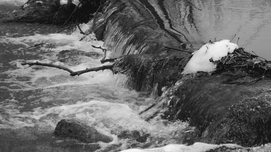 Black And White Photograph - Stream Cascades Over Small Dam by Rob Luzier