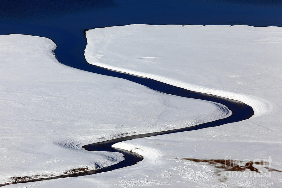 Stream flowing into a lake in winter Photograph by James Brunker