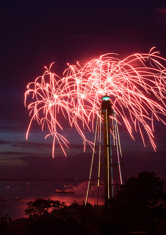 Streams of red fireworks burst over the Marblehead lighthouse