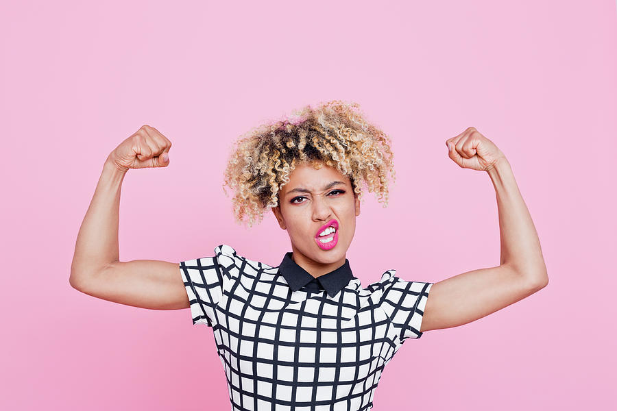 Strong afro american young woman flexing muscles Photograph by Izusek