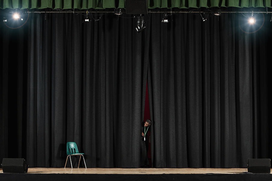 Student peering from behind curtain on stage Photograph by Hill Street Studios