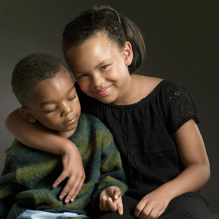 Studio Portrait Of An African American Girl Putting Her Arm Around Her Little Brother Photograph by Photodisc