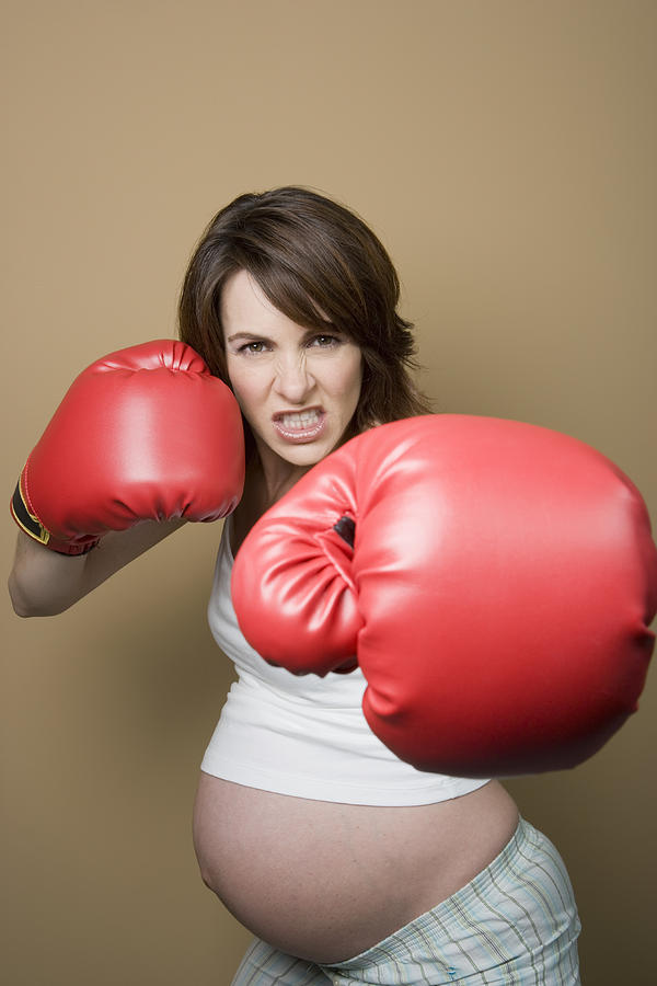Studio portrait of pregnant woman wearing boxing gloves Photograph by Sheer Photo, Inc