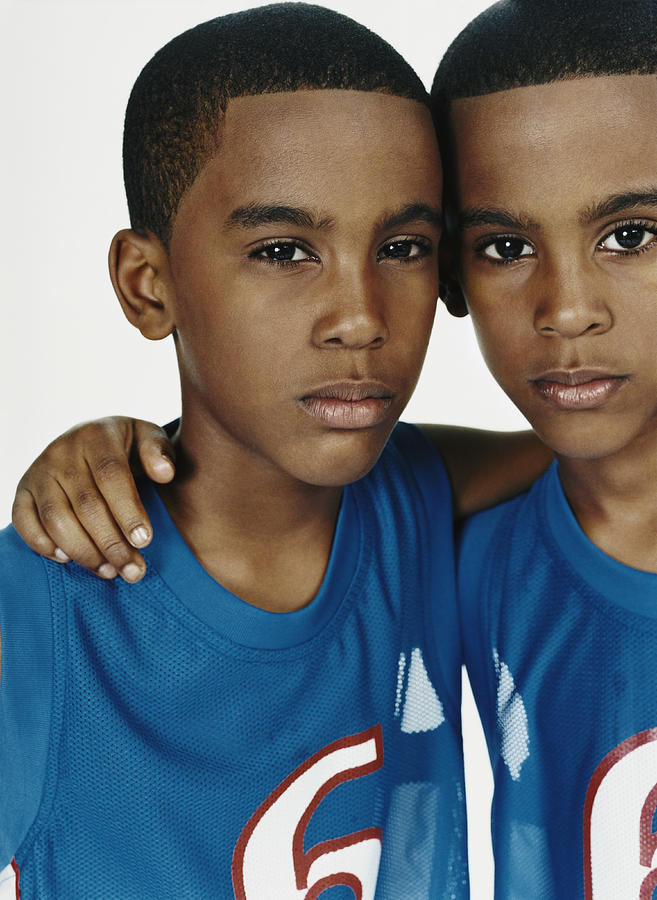 Studio Portrait of Twin Boys in Sports Strips Against a White Background Photograph by Digital Vision.