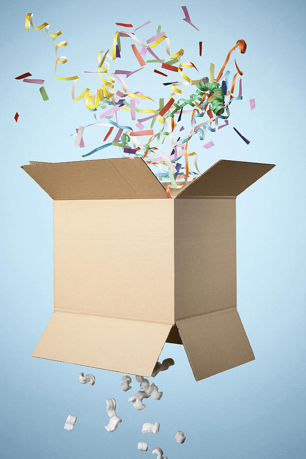 Studio shot of cardboard box with streamers exploding out Photograph by Sverre Haugland