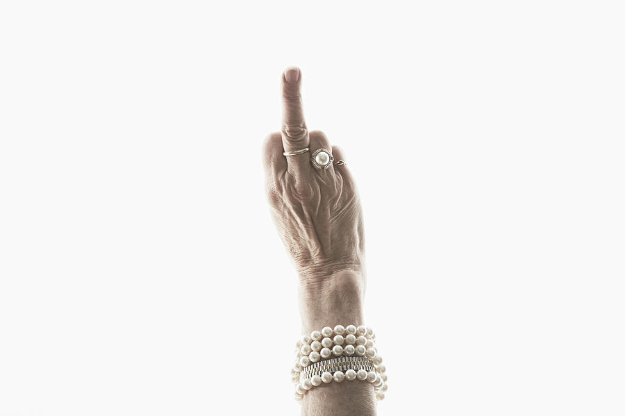 Studio shot of mature womans hand making obscene gesture Photograph by Jpm