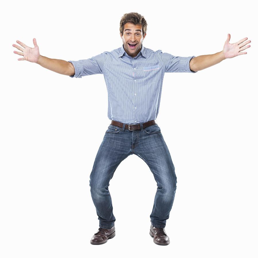 Studio shot of young cheerful man with arms outstretched Photograph by Momentimages