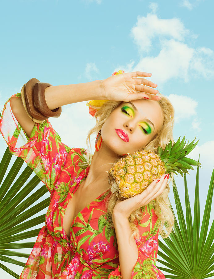 Summer portrait of attractive blonde woman holding pineapple fruit Photograph by Izusek