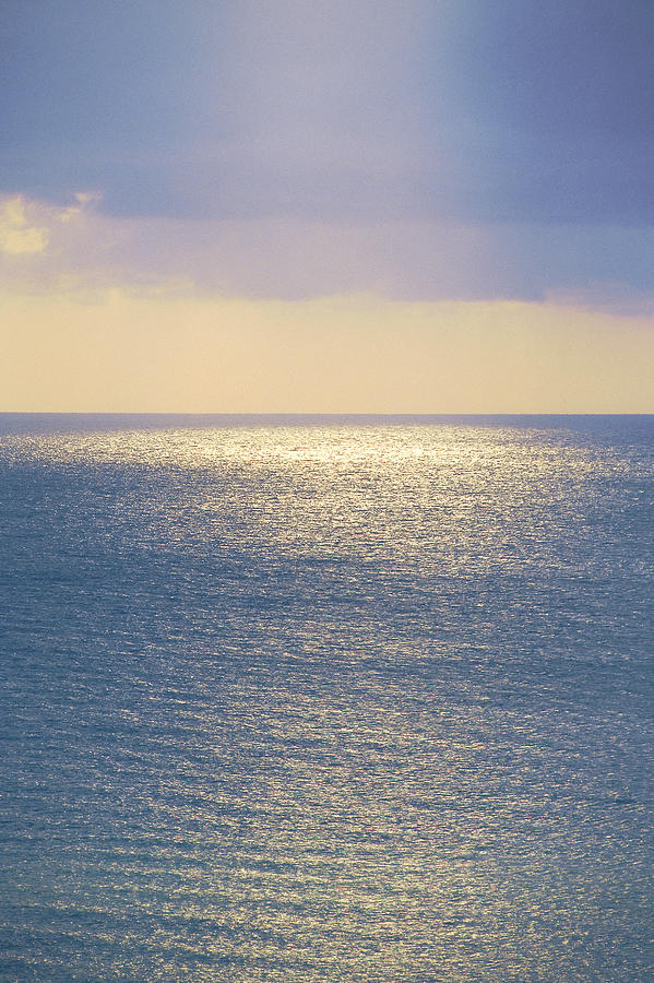 Sun reflecting on calm ocean Photograph by Comstock