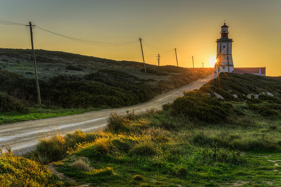 Sun Sets Behind The Lighthouse Photograph by Marco Oliveira