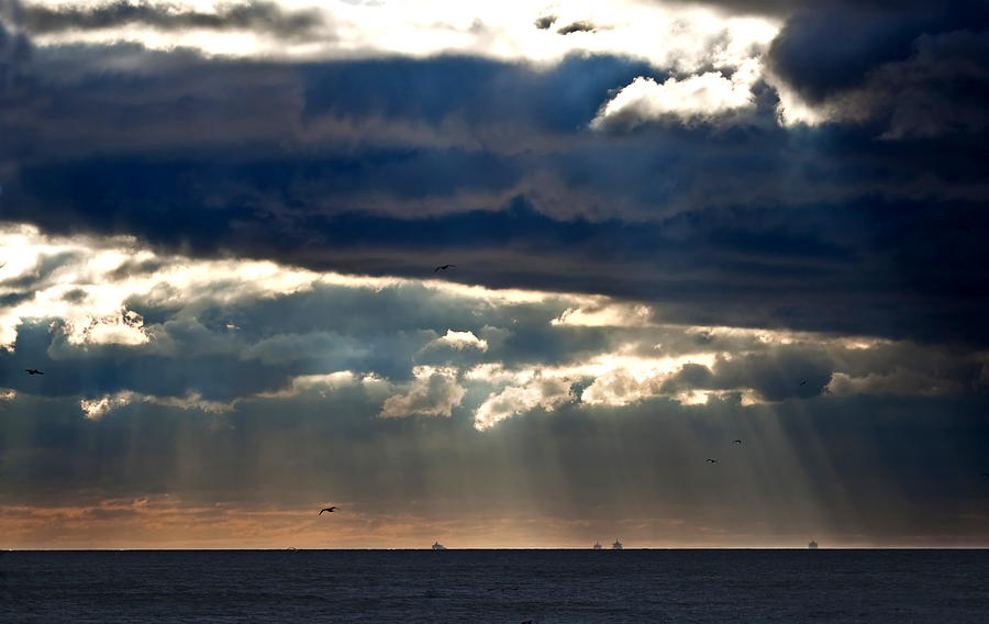 Nature Photograph - Sunbeams emanating through clouds above the ocean  by Mike Kusayev