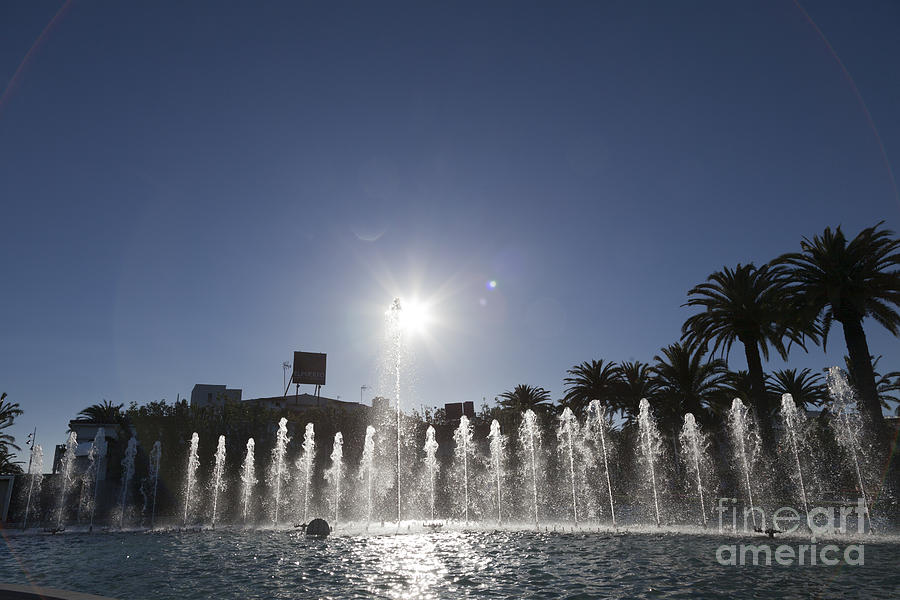 sunburst over fountains at  Palm Promenade Salou Photograph by Peter Noyce