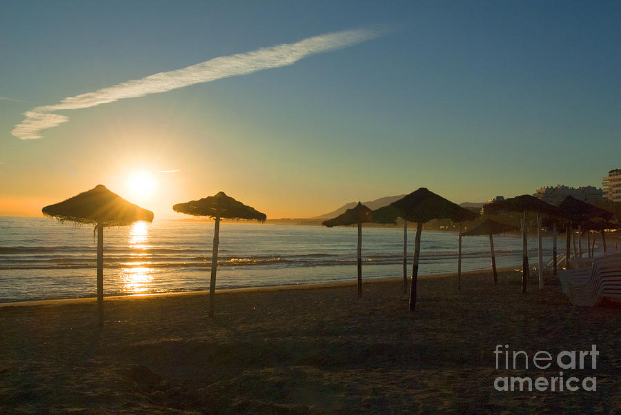 Sunset with umbrellas in Marbella Photograph by Brenda Kean