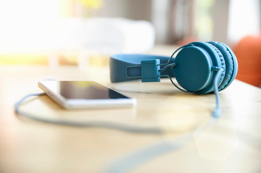 Surface level view of blue headphones attached to smartphone on table Photograph by Suedhang