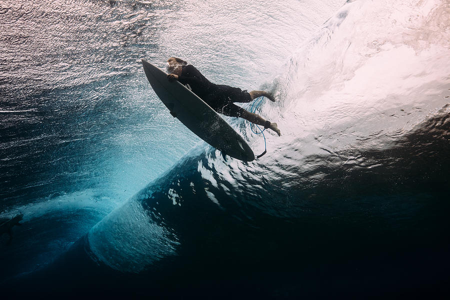 Surfer dives beneath a wave Photograph by Matt Porteous