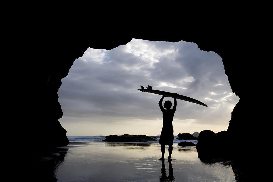 Sunset Photograph - Surfer Inside A Cave At Muriwai North by Deddeda