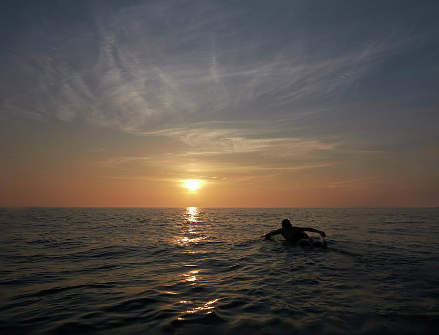 Surfer Paddling Out Toward Sunset Photograph by Dougal Waters