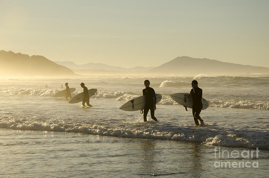Surfers in the sunset Photograph by Perry Van Munster