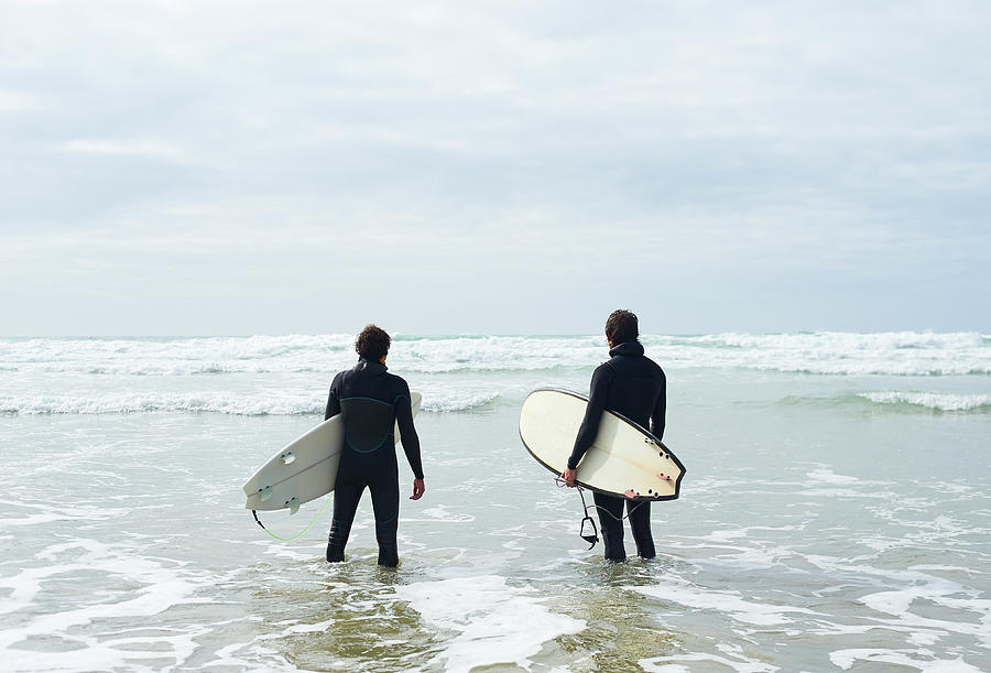 Surfers Stand With Their Boards Looking Photograph by Dougal Waters