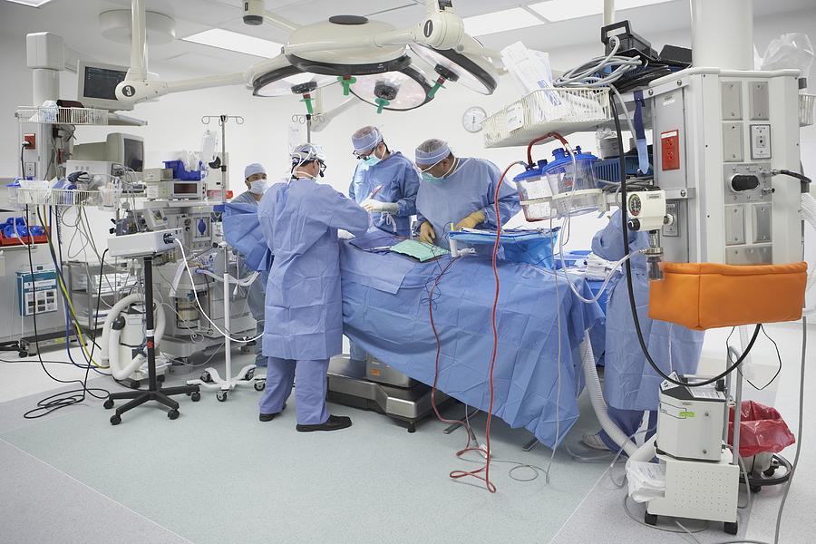 Surgeons performing surgery in operating room Photograph by ER Productions Limited