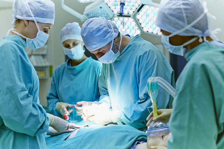 Surgeons performing surgery in operating room Photograph by Morsa Images