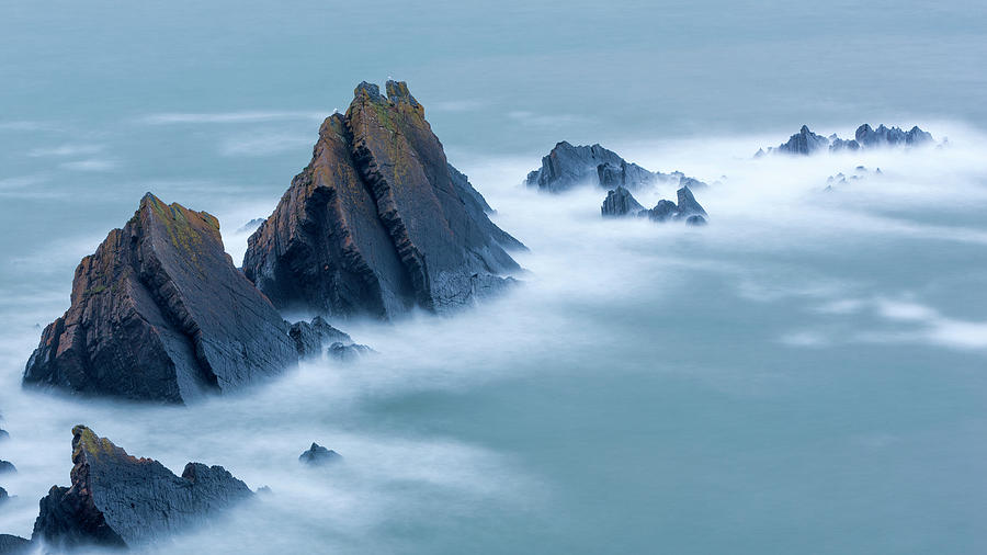 Swirling Tide Around Jagged Rocks Photograph by Sebastian Wasek