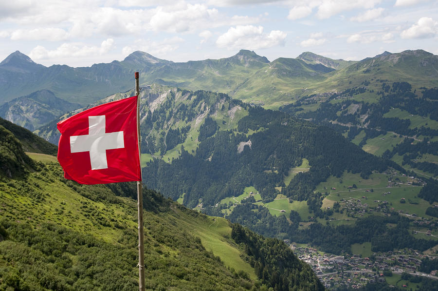 Swiss flag over Alps Photograph by Zmeel