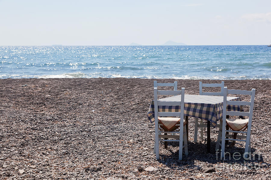 Table with chairs on the beach Tavern in Greece Santorini Photograph by Michal Bednarek