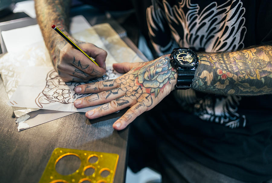 Tattoo artist designing motifs Photograph by Westend61