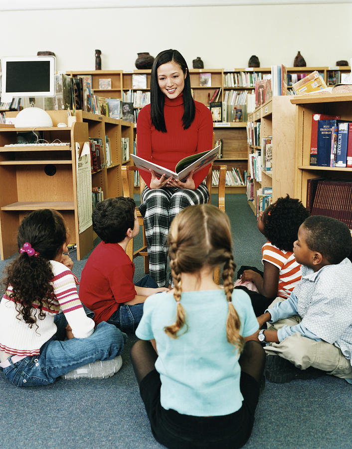 Teacher Reading a Story Book to a Small Group of Children in a Library Photograph by Digital Vision.