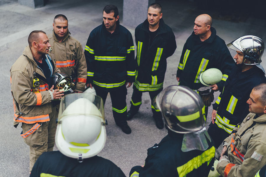 Team of firefighters listening to instructions Photograph by Martin-dm