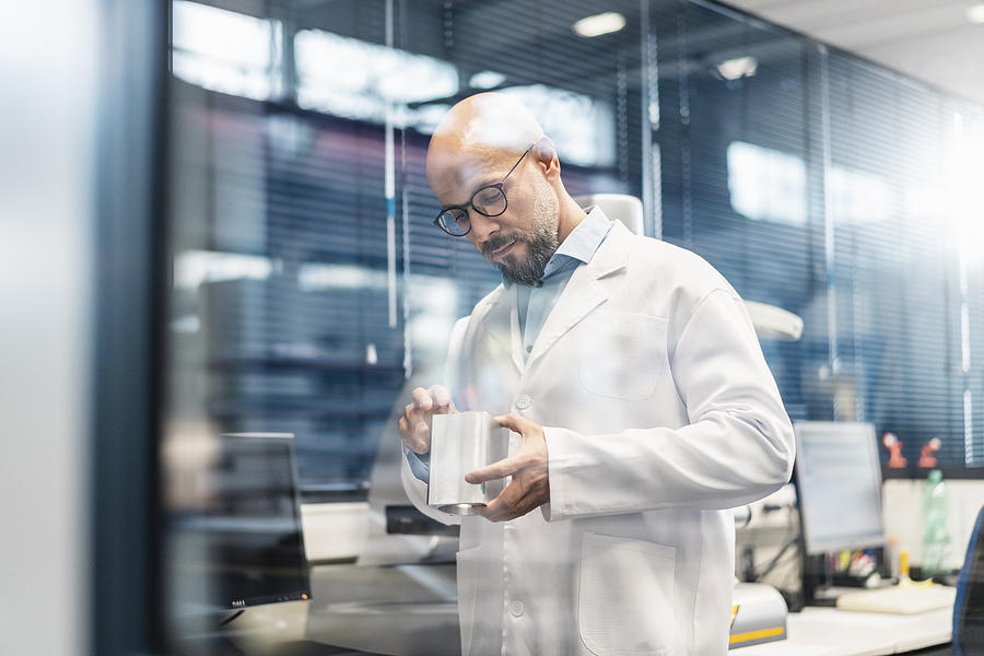 Technician wearing lab coat examining workpiece Photograph by Westend61 Technician wearing lab coat examining workpiece Photograph by Westend61