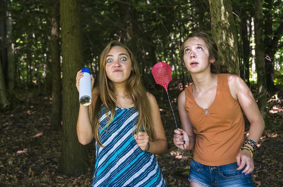Teen girls make faces chasing insects in a forest Photograph by Martinedoucet