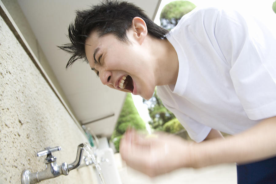 Teenage boy in gym cloth washing face and yelling, blurred motion Photograph by Daj