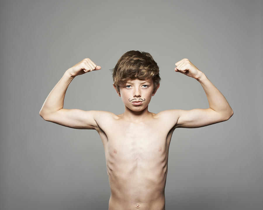 Teenage Boy Showing Muscles Photograph by Paul Viant