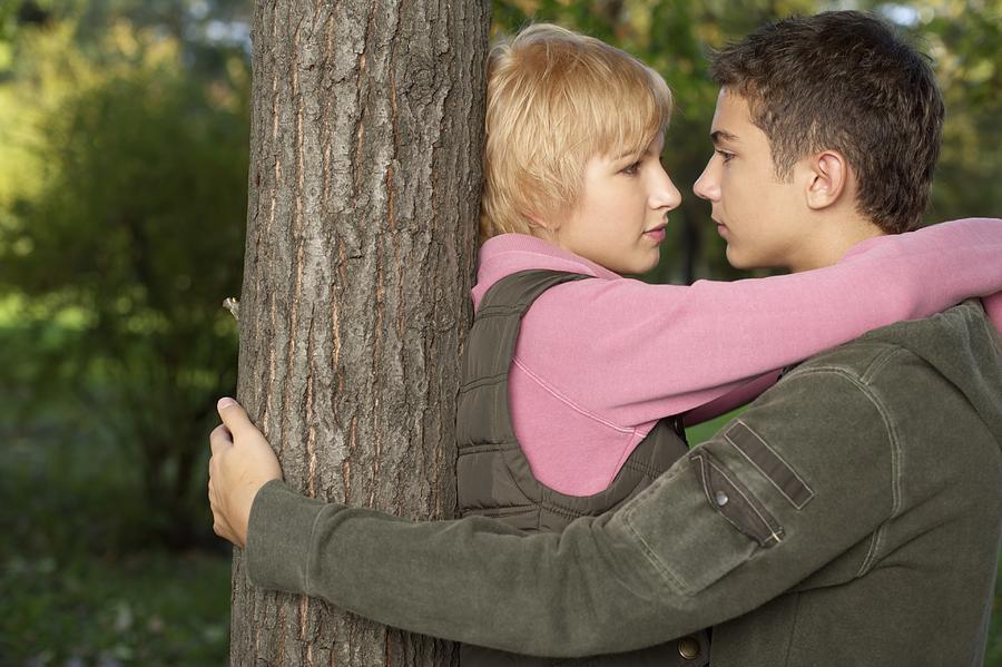 Teenage couple near a tree, selective focus Photograph by Stock4b-rf