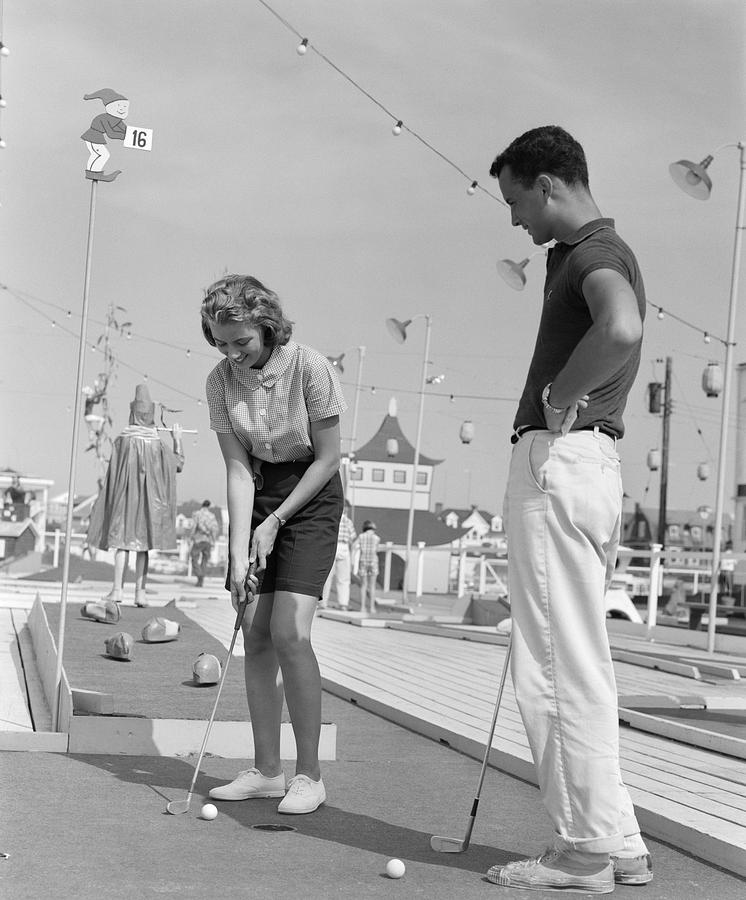 Teenage Couple Playing Miniature Golf Photograph by H Armstrong Roberts and ClassicStock